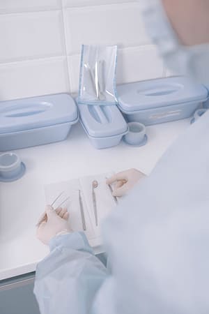 Medical professional arranging sterile surgical tools on a clean surface.