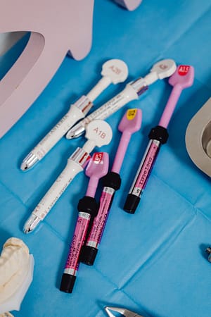 Close-up of colorful medical pens arranged on a blue surface, used in healthcare settings.