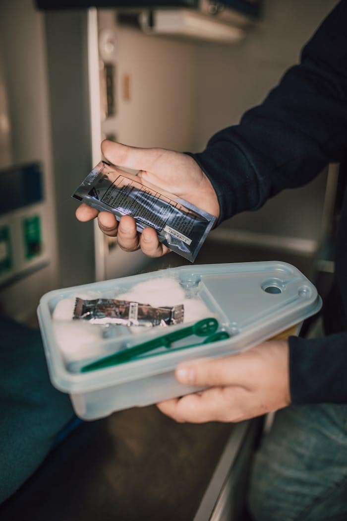 Hands holding a medical kit with various supplies, highlighting emergency preparedness.